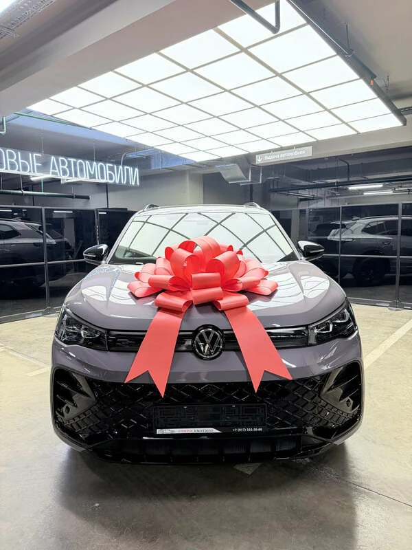 Volkswagen с красным бантом в зоне выдачи Drive